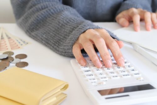 物価高で食費2万円を超え家計簿を見直す50代女性の冬のダイニング風景