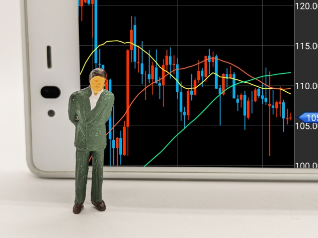 株価が下がり不安そうにグラフを見る50代のイメージ